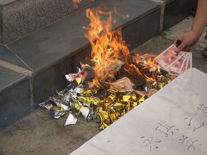 Låtsaspengar eldas på en kyrkogård i Kina. Foto Vmenkov